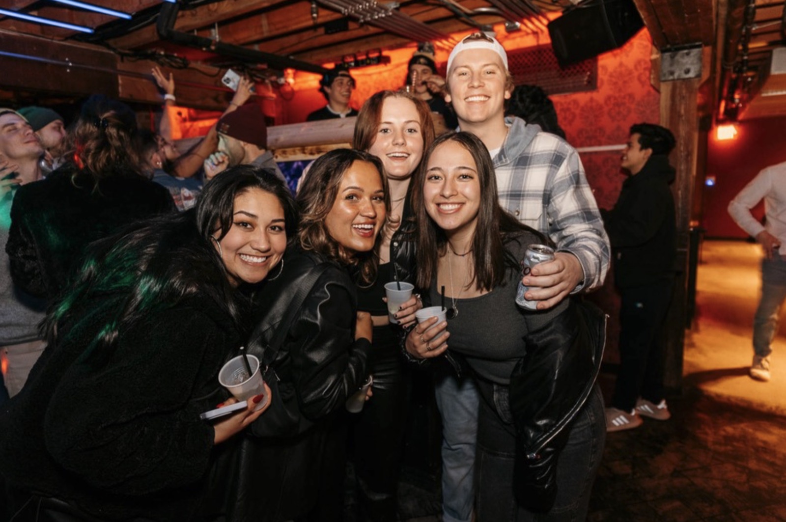 Friends posing with drinks at The Spotted James