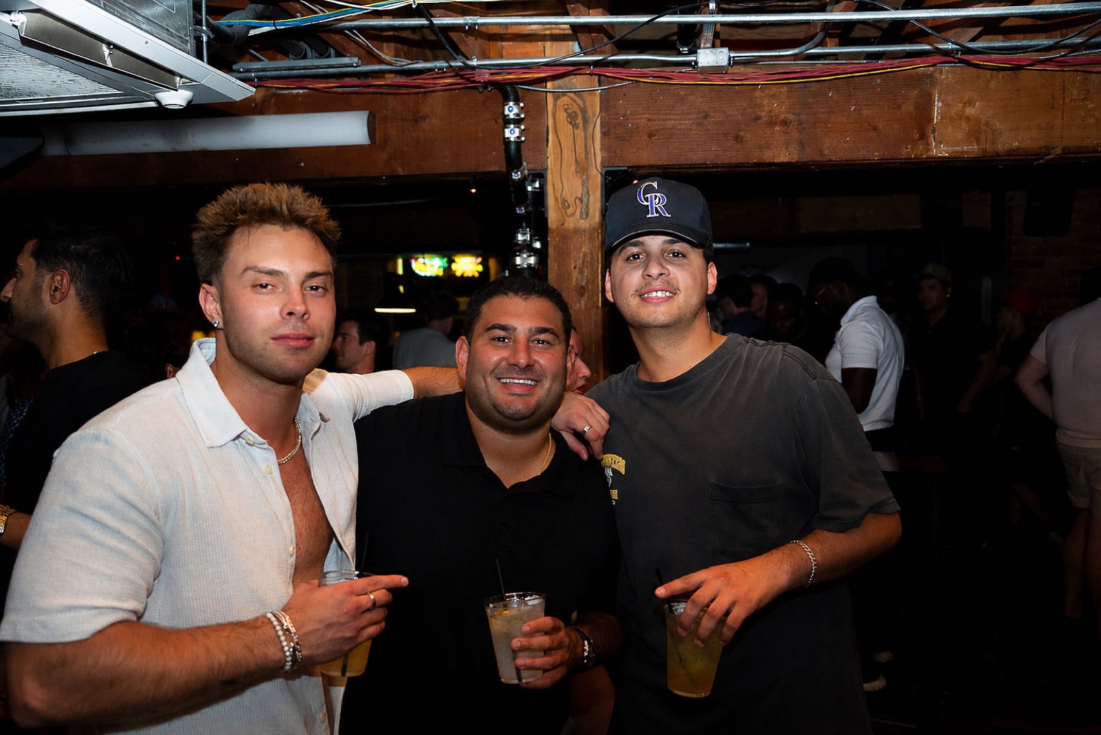 Friends with drinks in hand on a busy night